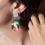 Studio Joy earrings with a woman among palm leaves on a model