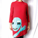 Red long sleeve dress with collage image of a face and hand sewn by Stella G