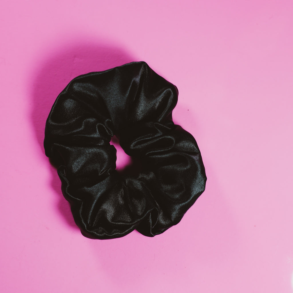 Black scrunchie on a pink background