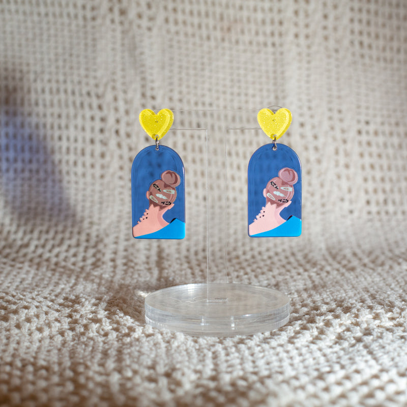 Blue dangle earrings with the back of a head and hairclips